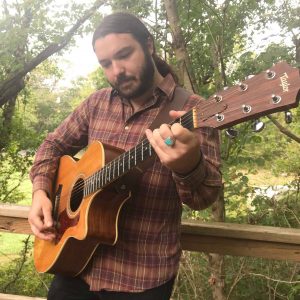 derek kretzer playing guitar outside in nature