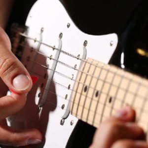 Man playing music after buying an electric guitar.