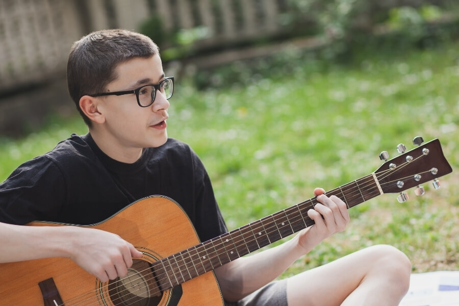 Teenager boy playing guitar