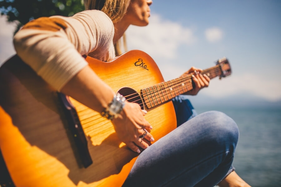 Woman Sitting playing guitar